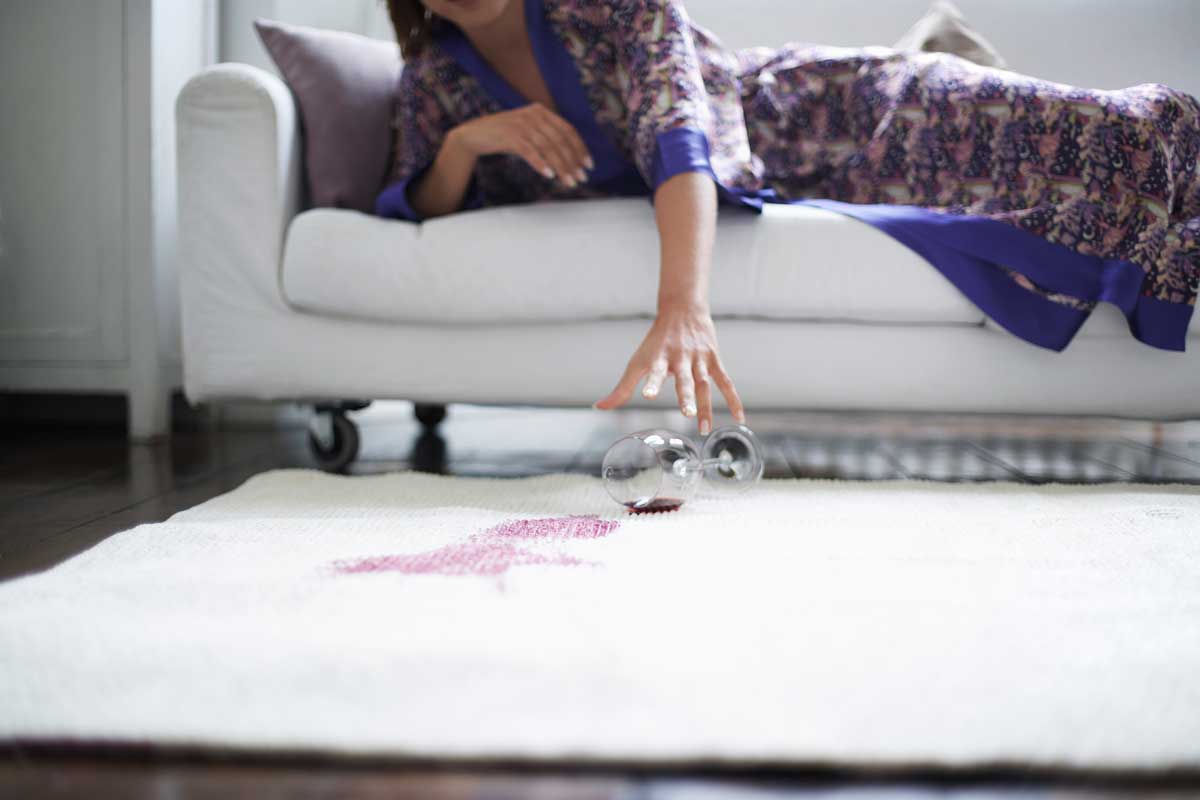 Woman on couch Spilling Red Wine on White Carpet
